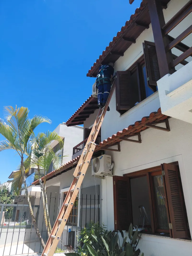 Escada apoiada na fachada durante instalação de split