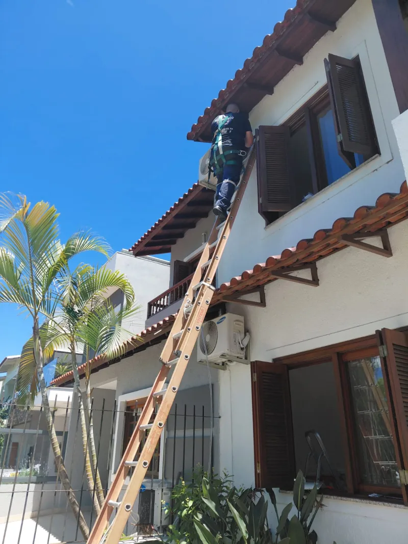 Técnico trabalhando em altura na fachada de uma casa
